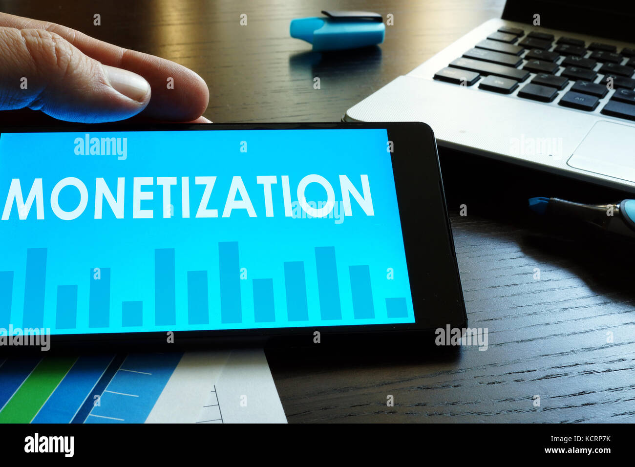 Man holding smartphone with word monetization. Stock Photo