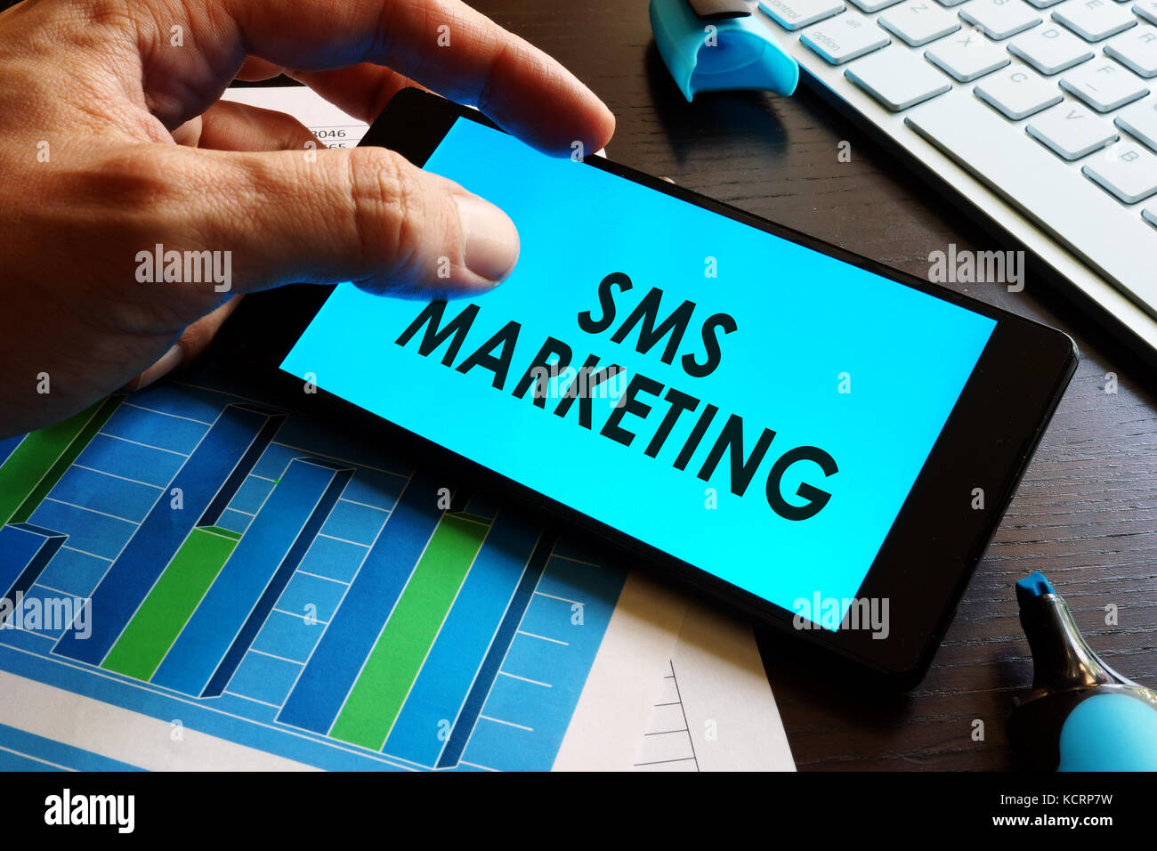 Man holding smartphone with words sms marketing. Stock Photo