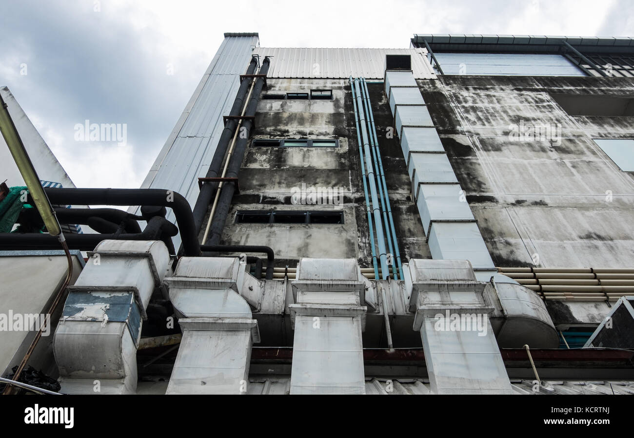 Air conditioning pipes and ventilation ducts were installed outside the building with cloudy blue sky background. Stock Photo