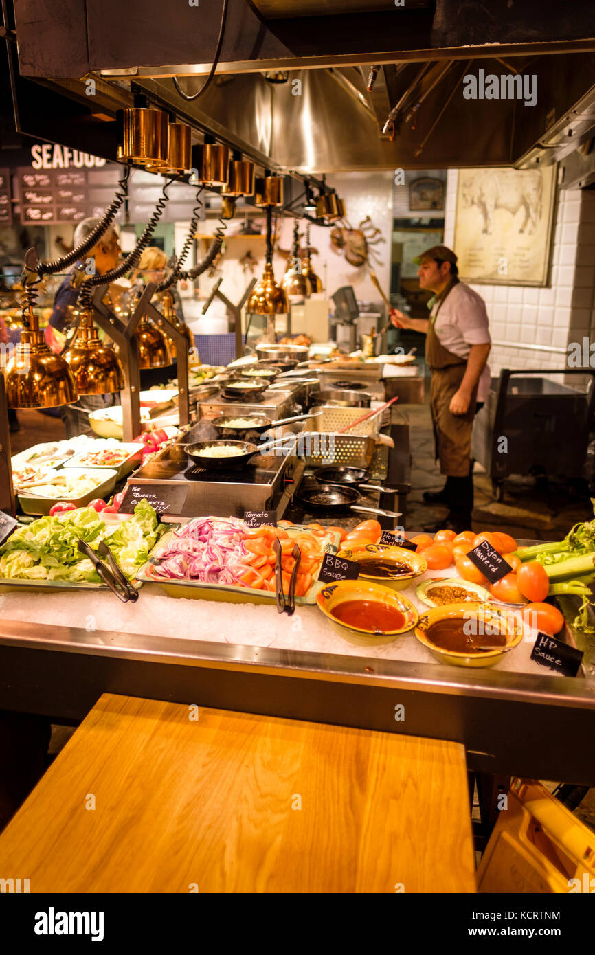 Customers waiting for a food order at one of the food stations at Marche Movenpick, downtown Toronto, Ontario, Canada. Stock Photo