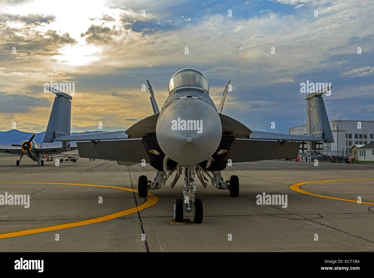 In this shot a U.S. Navy E/F-18E Super Hornet sits on the tarmac at sunset at the Historic Wendover Airfield in Wendover, Utah, USA. Stock Photo