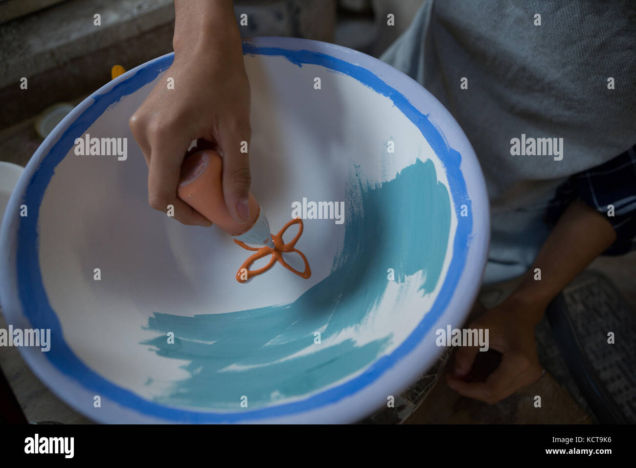 Male potters hand painting a bowl in pottery workshop Stock Photo - Alamy