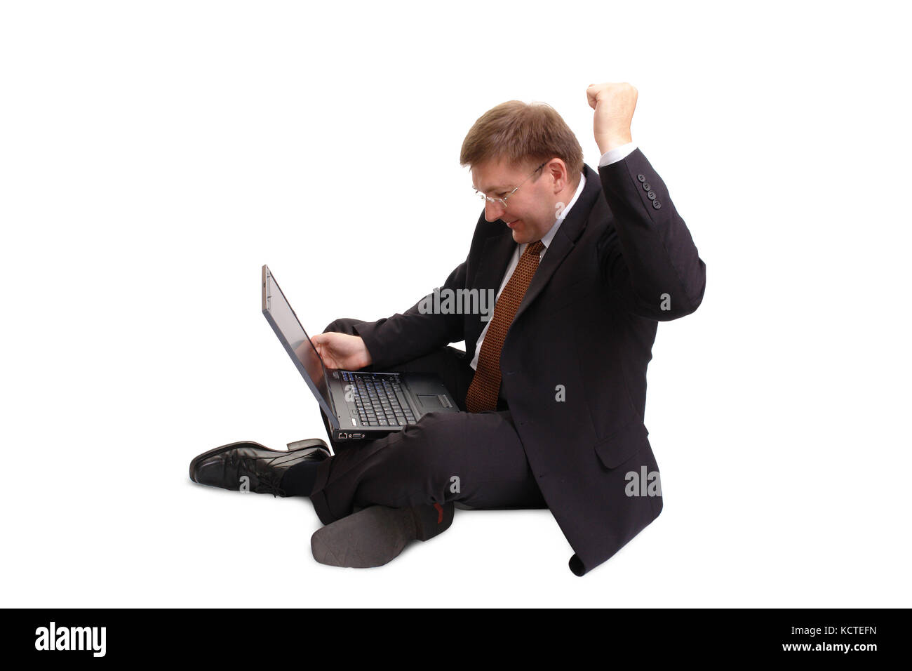 Young businessman in black suit sitting cross-legged working with ...