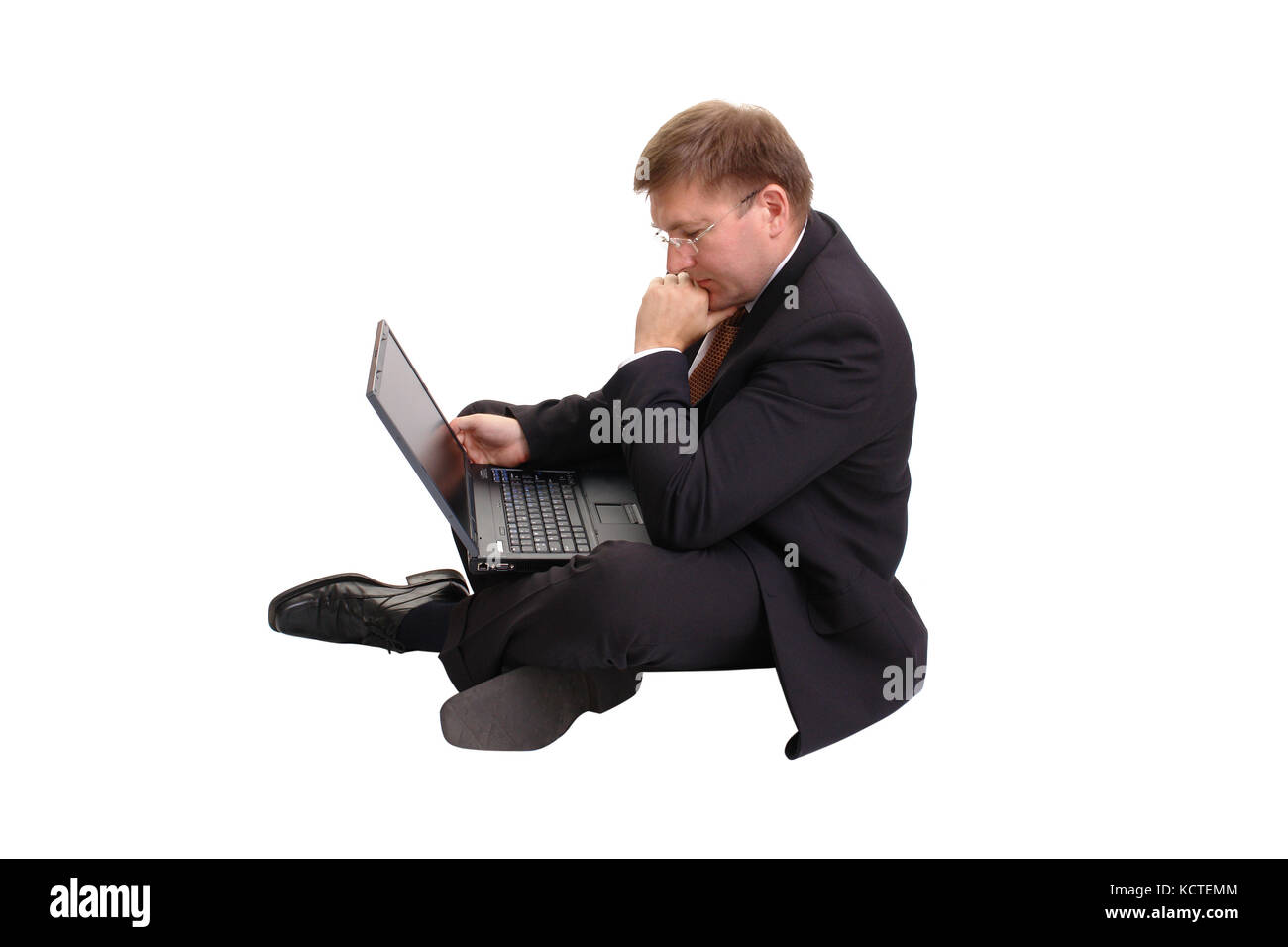 Young businessman in black suit sitting cross-legged working with ...
