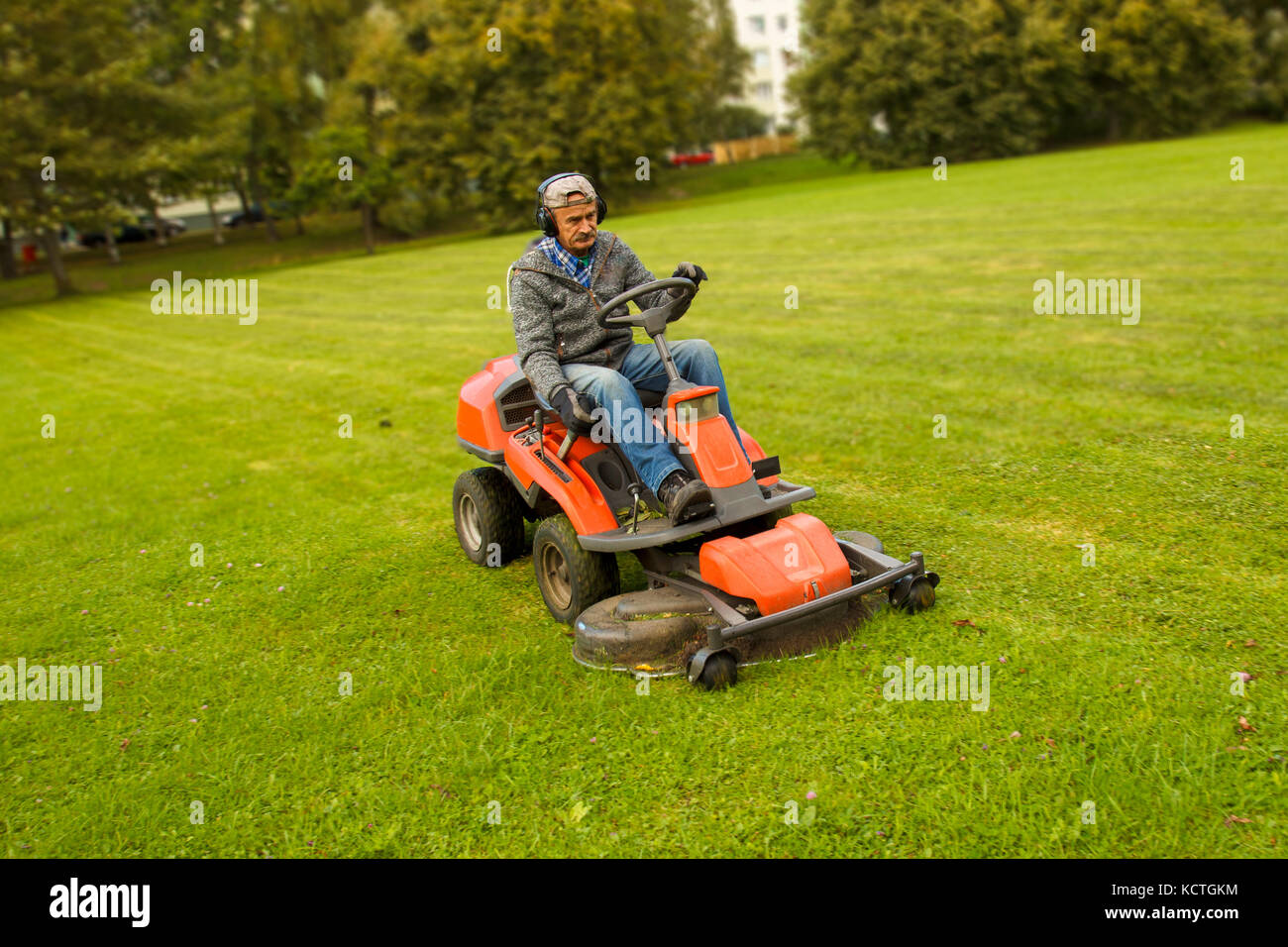 man riding lawn mower Stock Photo
