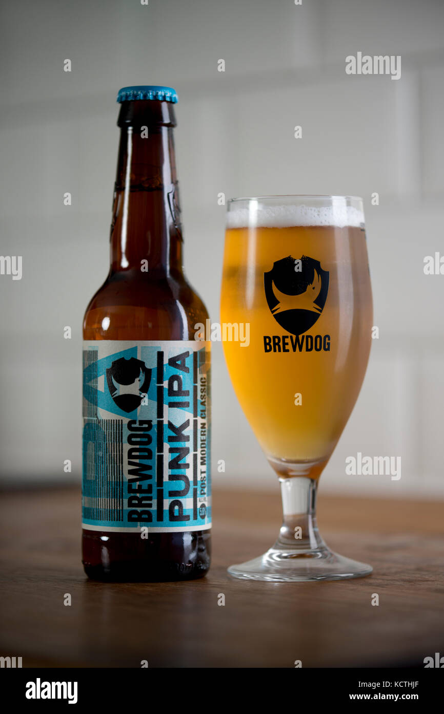 A bottle of BrewDog Punk IPA stands beside a BrewDog branded glass filled with beer (Editorial use only). Stock Photo