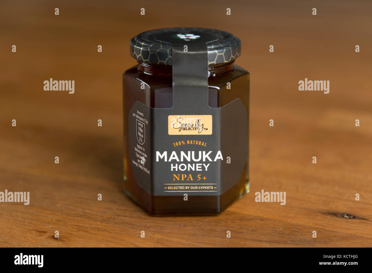 A jar of Aldi Specially Selected Manuka honey is shot against a wooden background (Editorial use only). Stock Photo