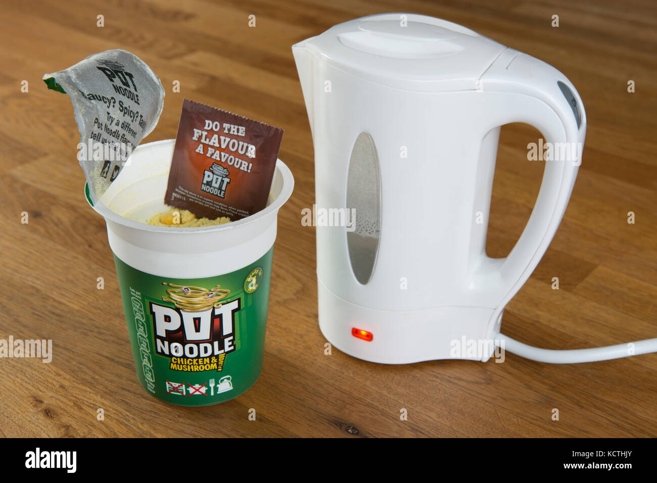 A Unilever Pot Noodle (Chicken and Mushroom flavour) in the process of being prepared using boiling water from a kettle (Editorial use only). Stock Photo
