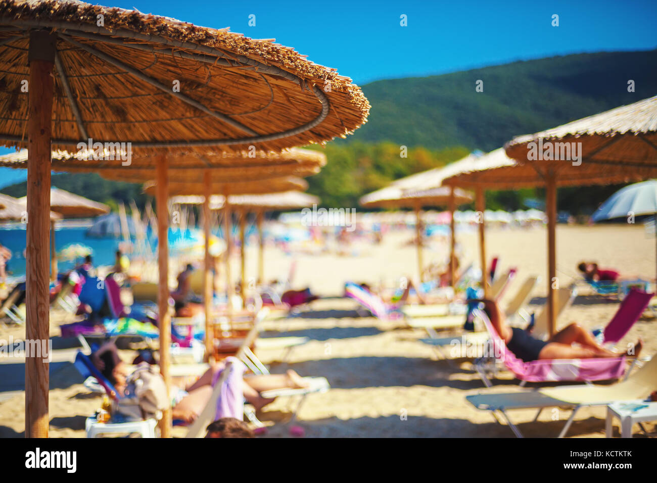 Summer season, being on the beach, focus on small part of reed sun umbrella. Stock Photo