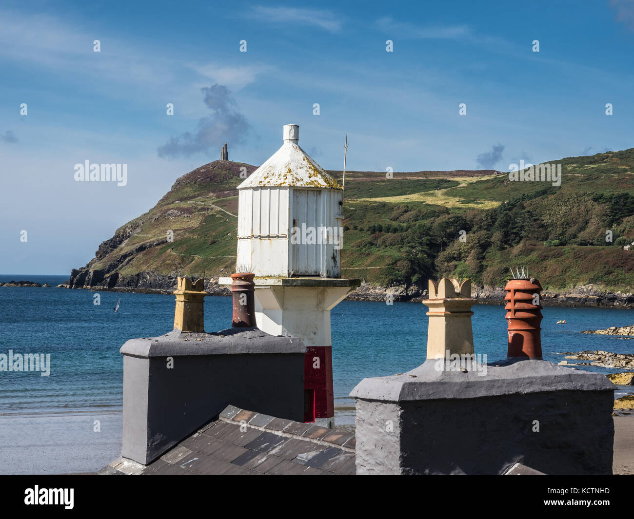 Port Erin Lighthouse over the rooftop of Cosy Nook Cafe with Bradda Head in the background. Isle of Man. Stock Photo