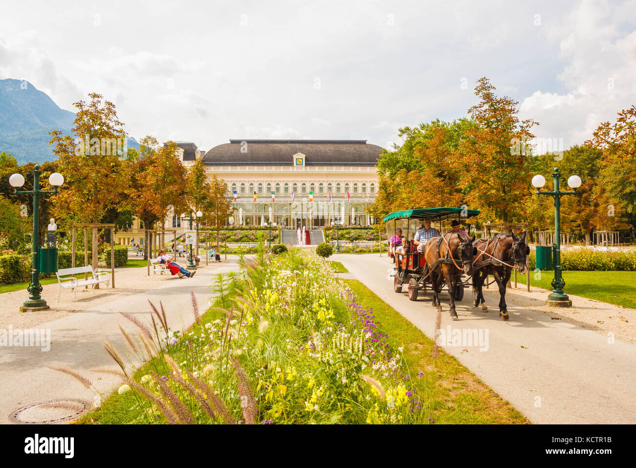 Bad Ischl, Austria - September 2, 2016: A horse-drawn carriage with tourists rides through a park in front of the Congress and Theaterhouse (Kongress  Stock Photo