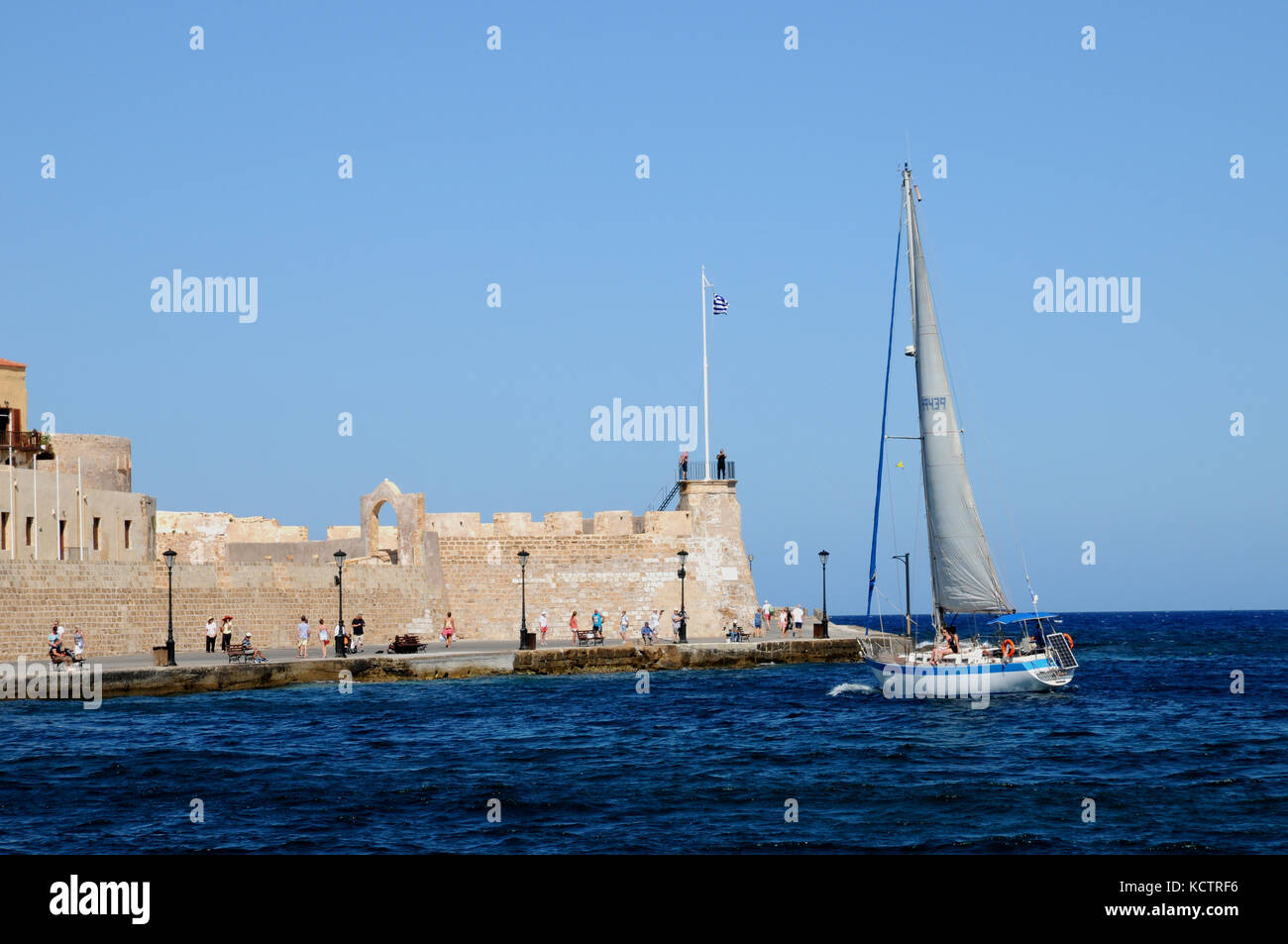 A sailing boat at the entrance to the Venetian Harbour in the Cretan town of Chania. Stock Photo