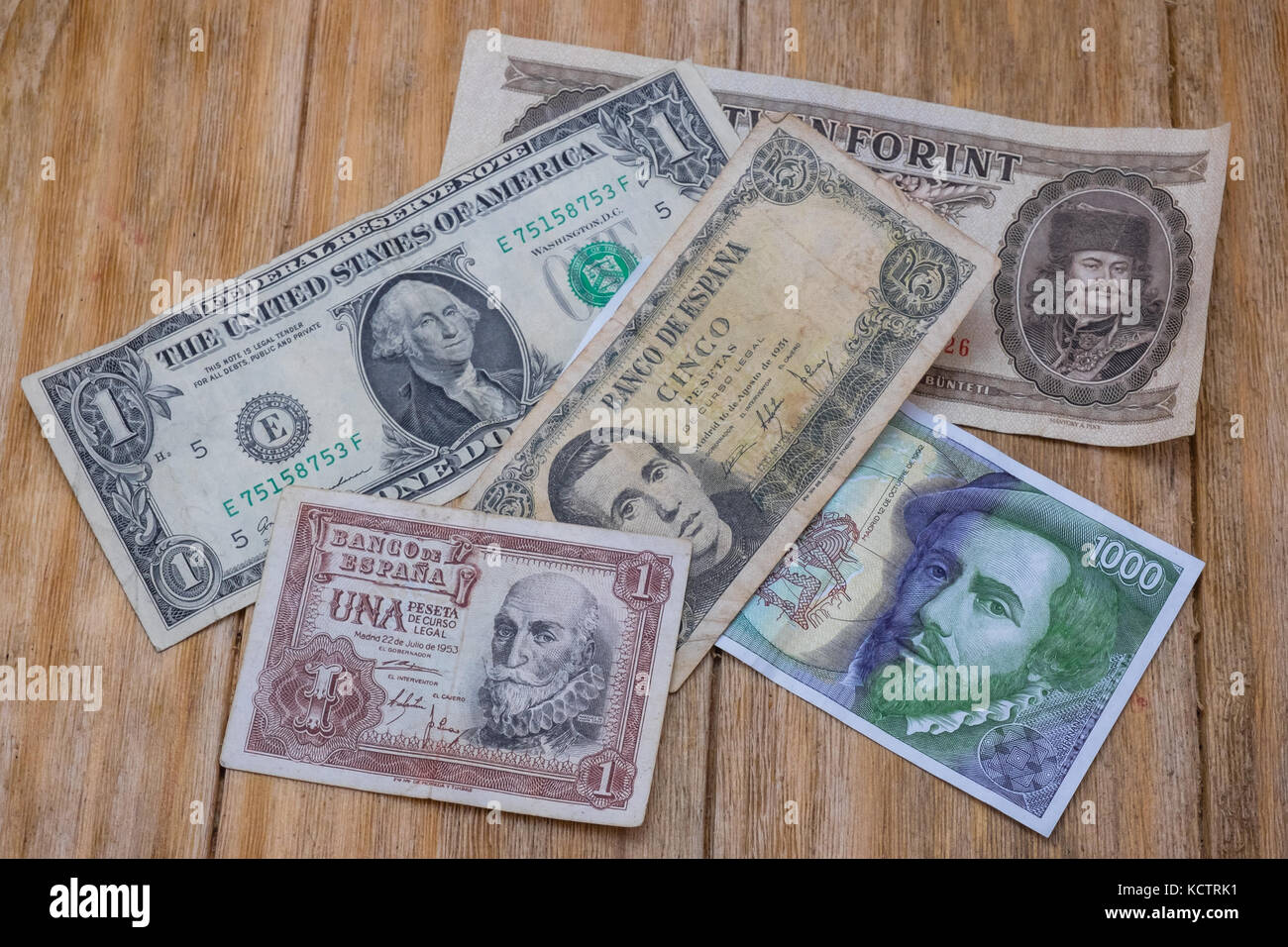 several bills Spanish pesetas, US dollar and Hungarian forint over a wooden  table Stock Photo - Alamy