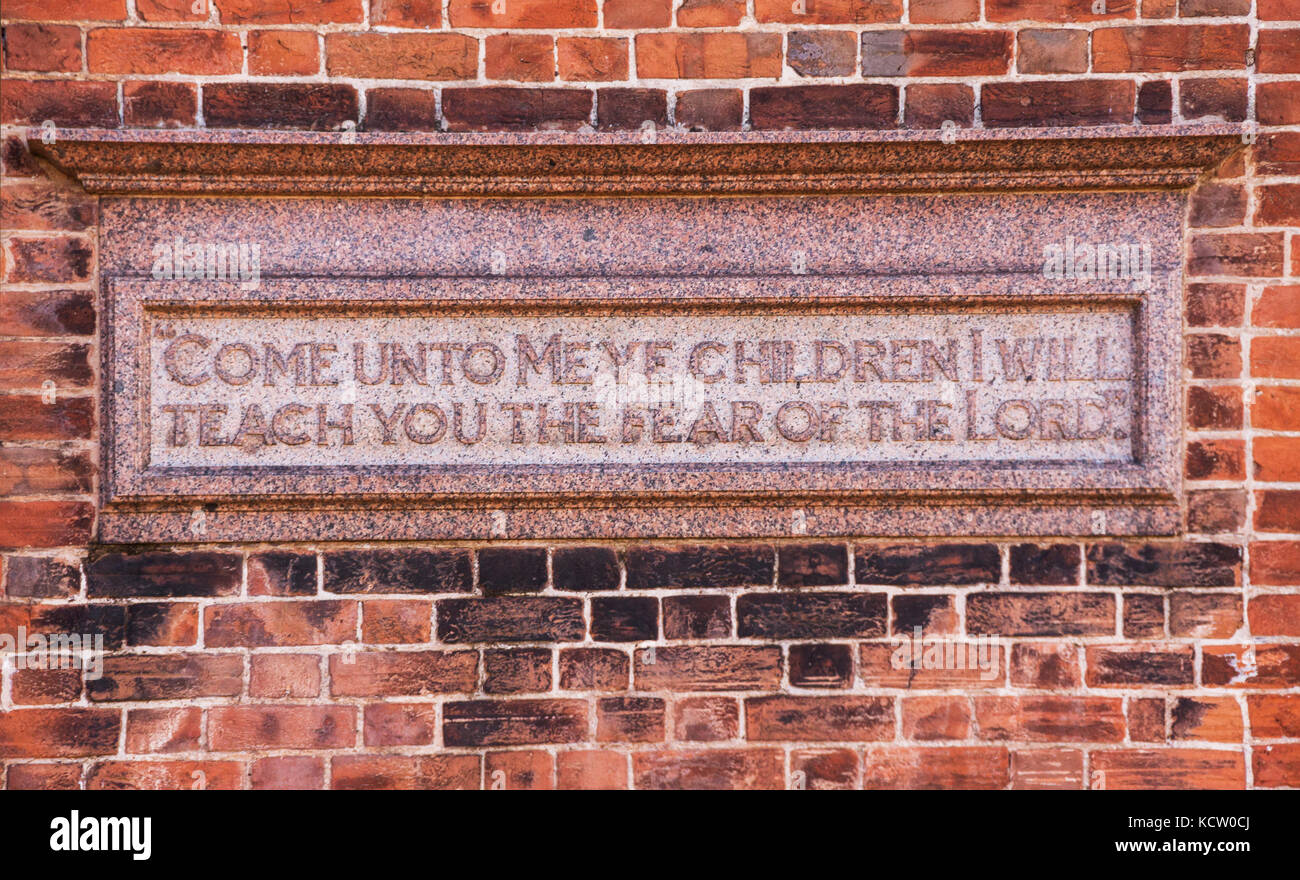 Plaque depicting 'Come unto me ye children, I will teach you the fear of the Lord' on a wall beside Kennaway House,(once Church House) in Sidmouth Stock Photo