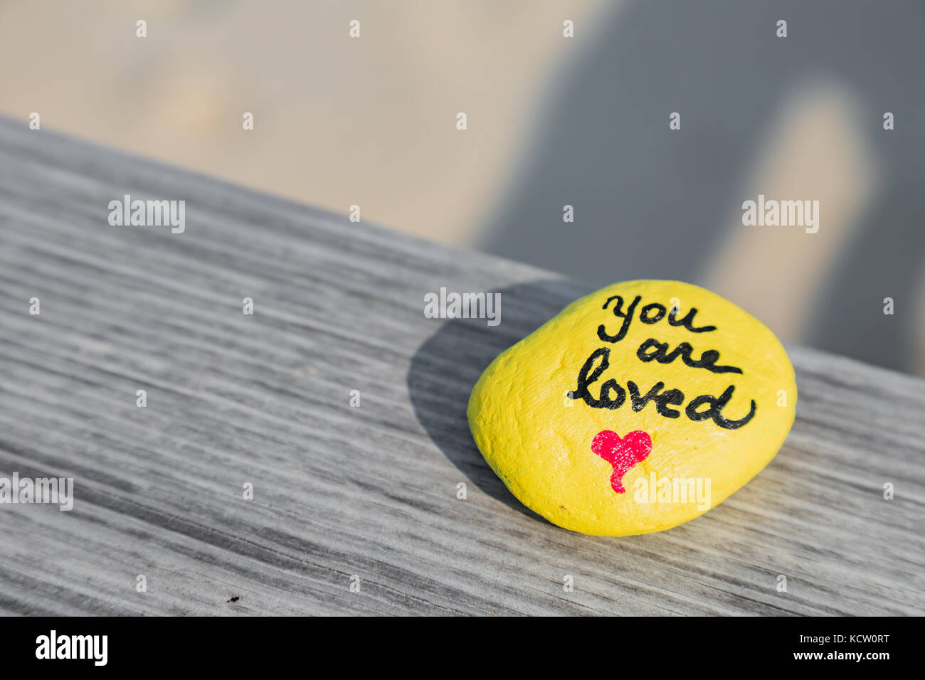 People create kindness rocks for others to find. This one was spotted at the beach. Stock Photo