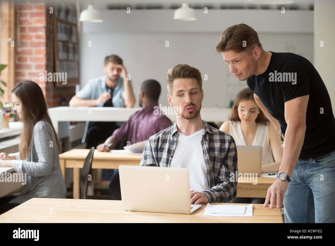 Casual entrepreneur explaining business project to his coworker. Two