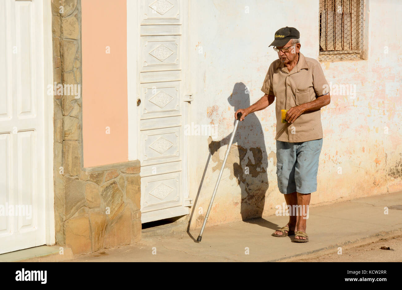 Older man walking with a cane, Trinidad,  Cuba Stock Photo