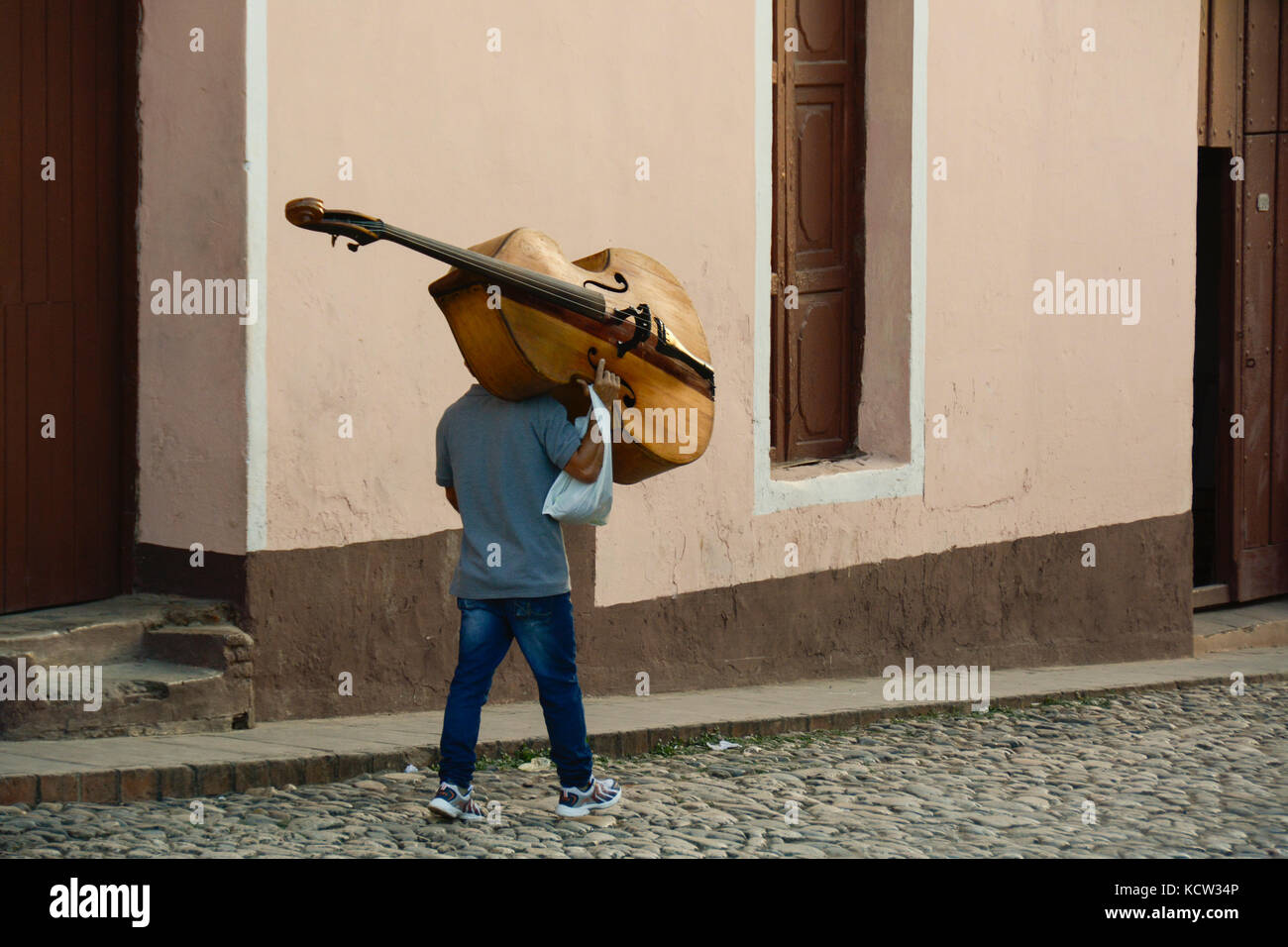Man carrying a Double bass, Trinidad,  Cuba Stock Photo