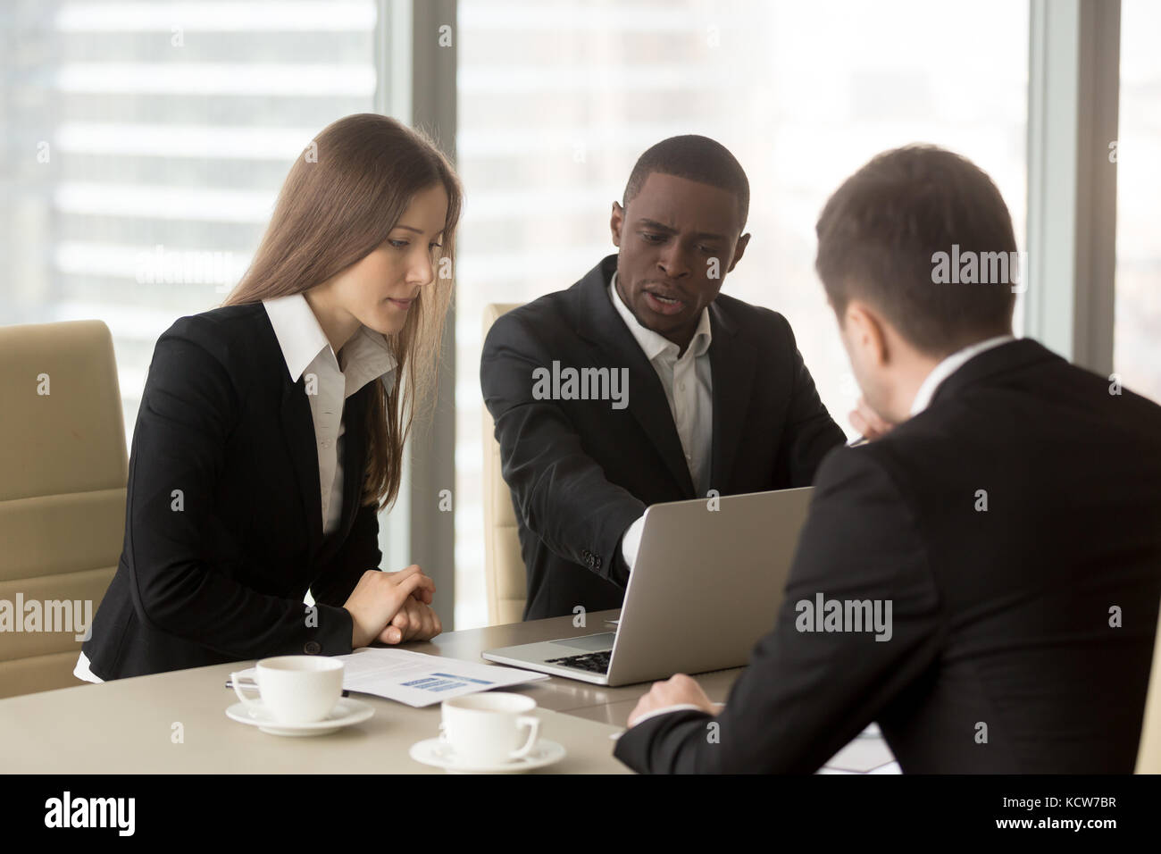 Group of multinational financiers working together on company strategy, planning financial results, examining marketing researches. Black businessman  Stock Photo
