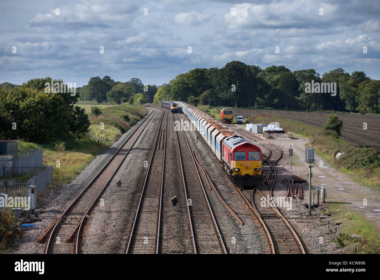 A First Great Western  high speed train overtakes a DB Cargo freight train at Woodborough between Pewsey & Westbury, Wiltshire UK Stock Photo