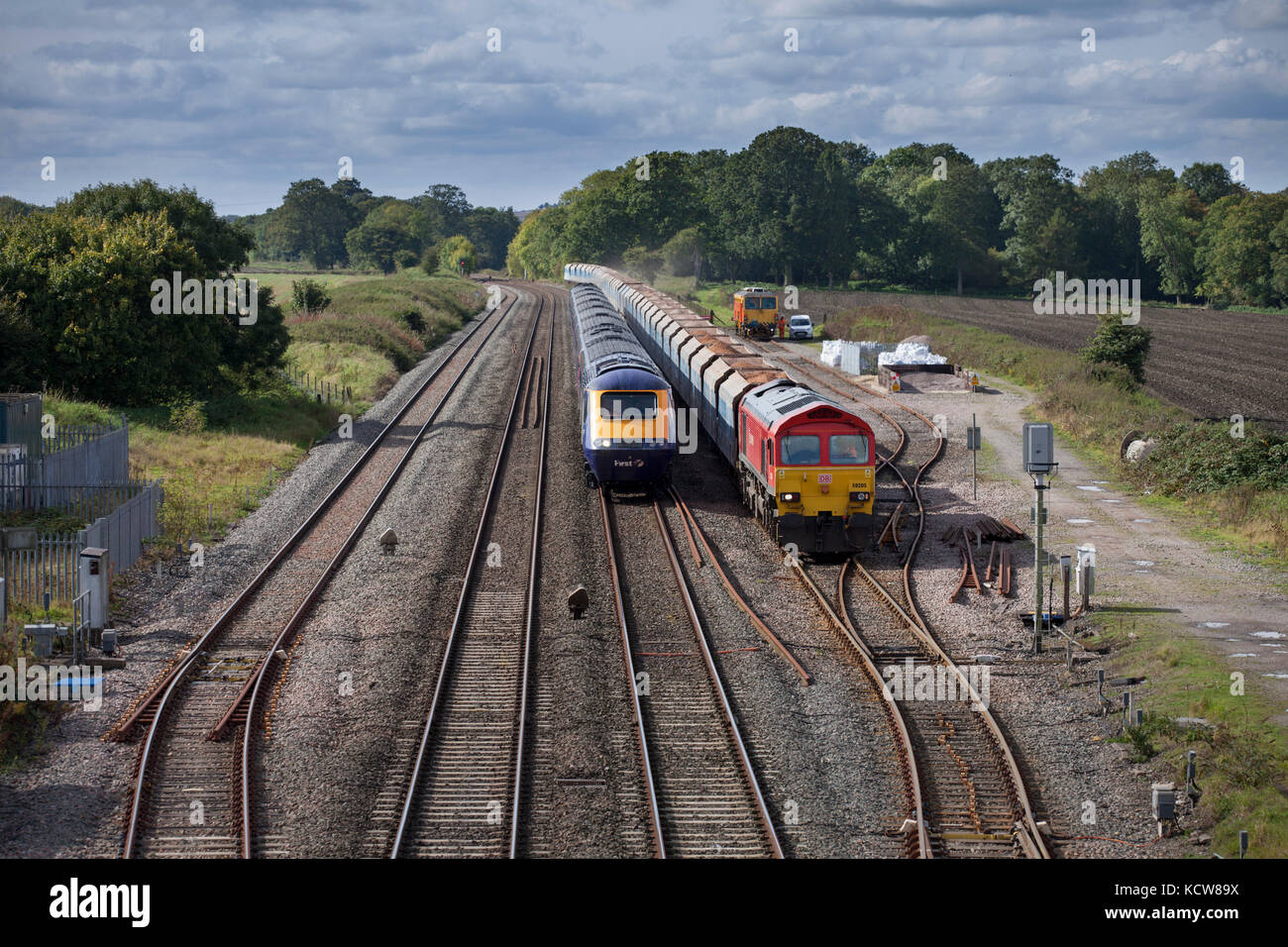 A First Great Western  high speed train overtakes a DB Cargo freight train at Woodborough between Pewsey & Westbury, Wiltshire UK Stock Photo