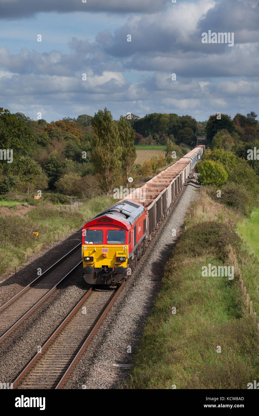 A Db cargo class 59 locomotive passes Woodborough (between Pewsey & Westbury, Wiltshire ) hauling empty stone wagons from London to Merehead Quarry Stock Photo