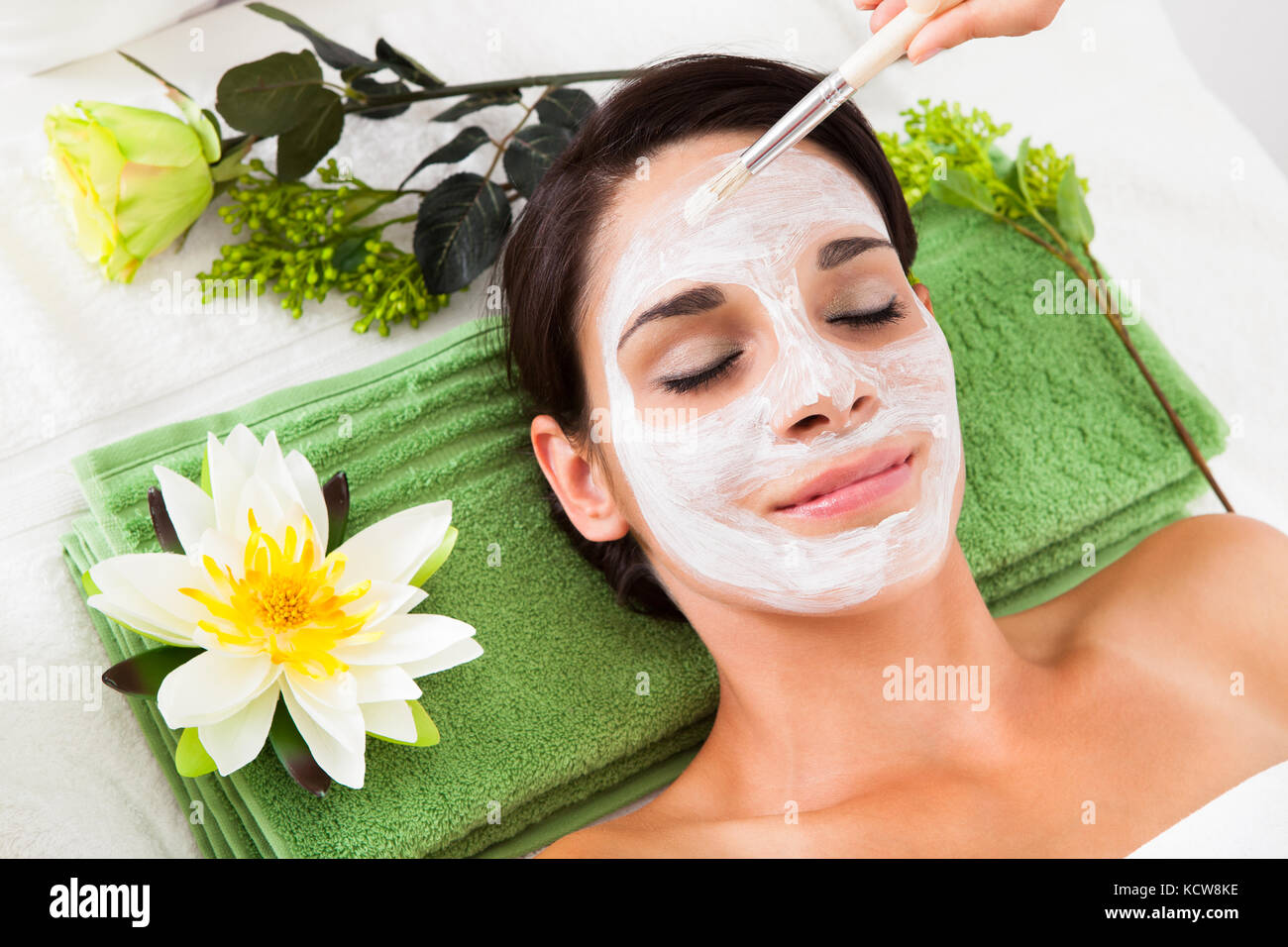 Cosmetician Applying Facial Beauty Mask For Young Woman At Spa Salon Stock Photo