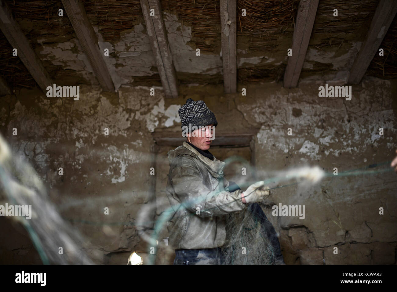 Every day, fishermen spend hours cleaning the nets, they gather in groups and share the work. Tastubek, the 18 of April 2016. Longue séance de travail Stock Photo