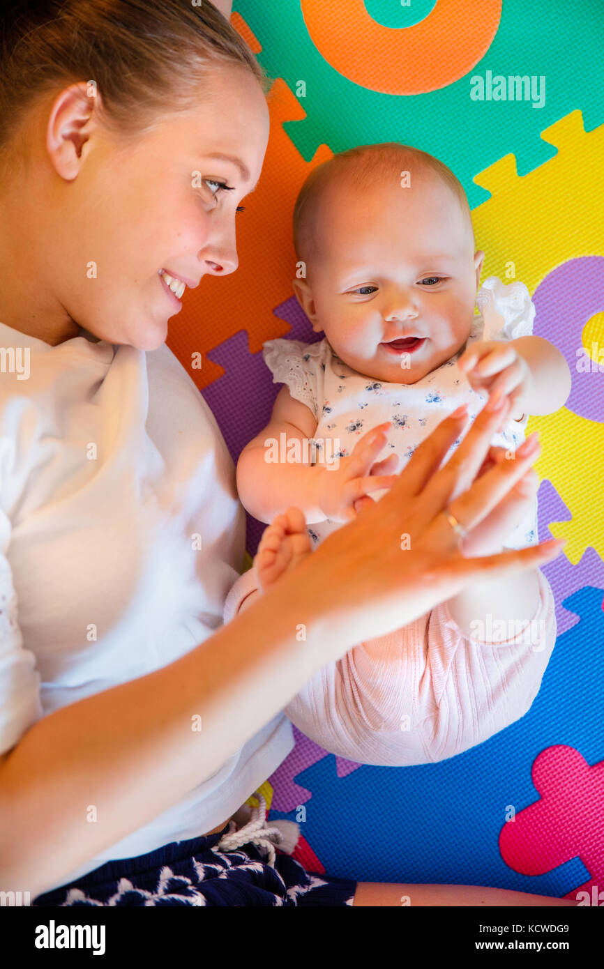 Cute baby girl playing with her caring mother Stock Photo