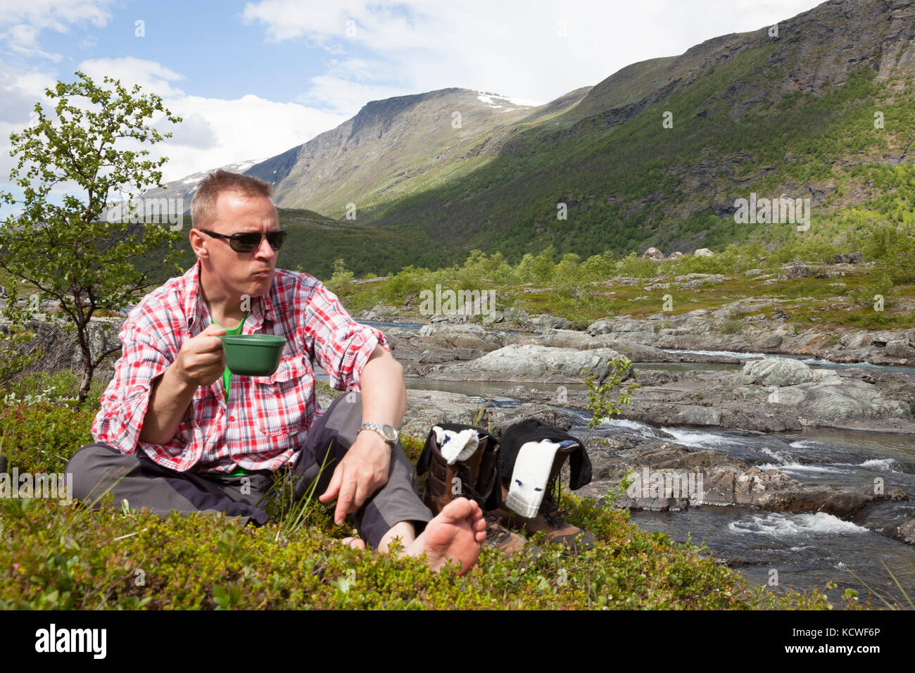 Hiker enjoys a cop of coffee in the mountains Stock Photo