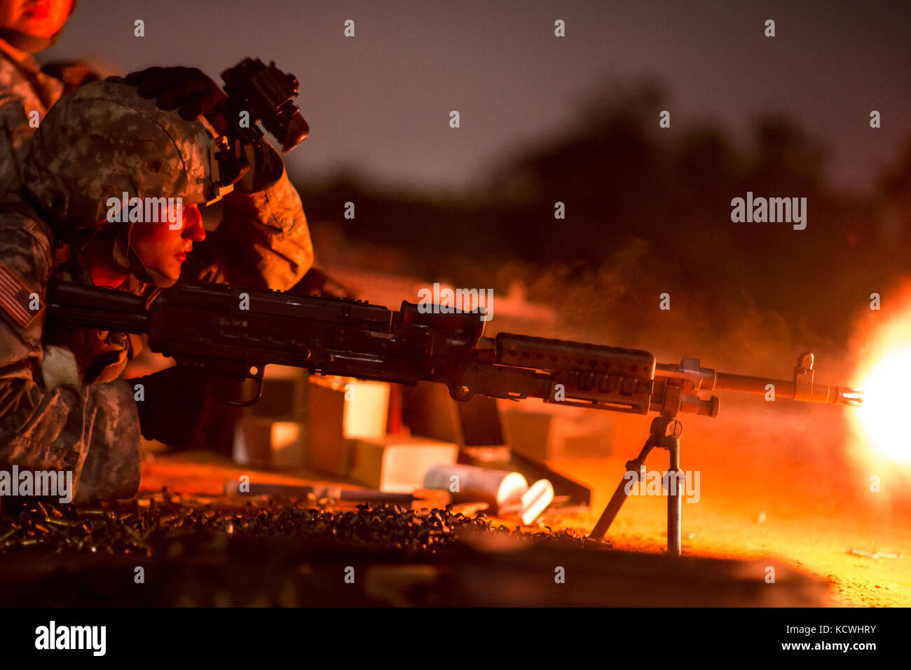 U.S. Army Spc. Edward Carr, combat engineer assigned to the 218th Maneuver Enhancement Brigade, S.C. Army National Guard fires a M240B machine gun during the crew-served weapons familiarization night training at Fort Jackson, S.C., Sept. 15, 2016.  Carr is assisting in the training of 30 Soldiers from multiple transportation and signal companies on dismounted security drills and crew-served weapons in preparation for their qualification next summer and to stay current with convoy security. (U.S. Air National Guard photo by Tech. Sgt. Jorge Intriago) Stock Photo