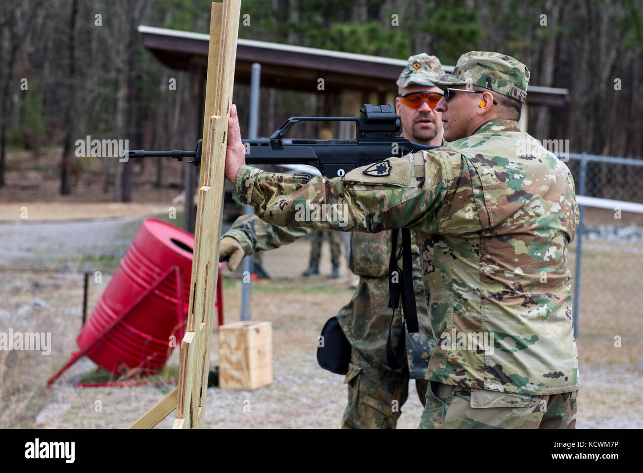 German Army Master Sgt. Franco Kraemer a liaison officer assigned to German Armed Forces Command of U.S. and Canada instructs U.S. Army Chief Warrant Officer 2 Dagoberto Quiroz an apache pilot with the South Carolina Army National Guard where to aim the G36 rifle during the German Proficiency Badge course at a firing range near the McCrady Training Center, Eastover, S.C., March 3, 2016.   (U.S. Air National Guard photo by Tech. Sgt. Jorge Intriago/Released) Stock Photo
