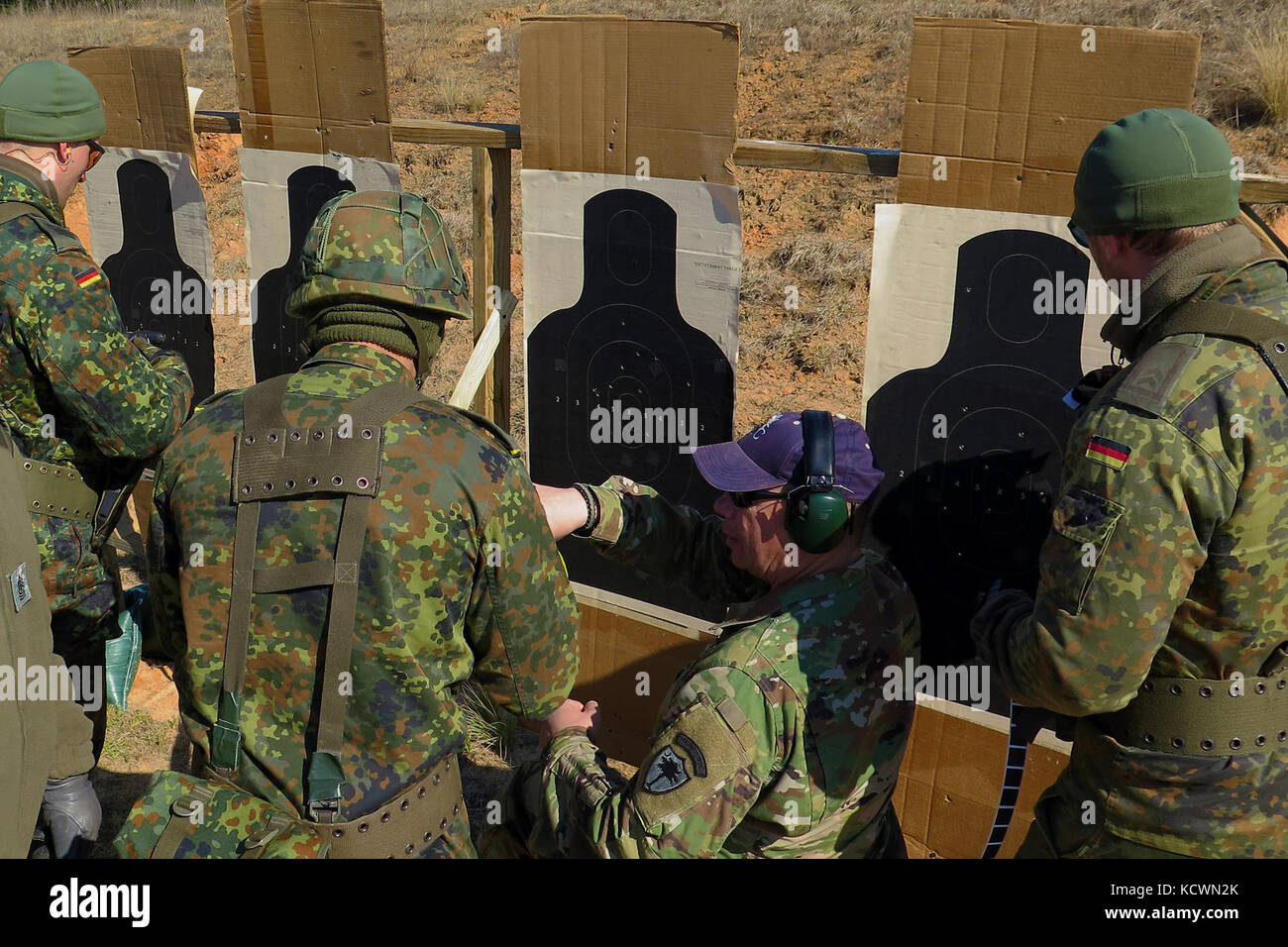 A marksmanship team from Germany checks their target at an M9 weapons competition. Military members participated in the annual South Carolina National Guard TAG match during the M9 pistol marksmanship portion at a firing range near the McCrady Training Center, Eastover, South Carolina, March 6, 2016.  More than 50 participants joined the TAG match competition held March 5-6, hosted by the South Carolina Army National Guard's Marksmanship Training Unit and included teams from the S.C. Air National Guard, Fort Jackson, and a team from Germany. (U.S. Army National Guard photo by Lt. Col. Cindi Ki Stock Photo