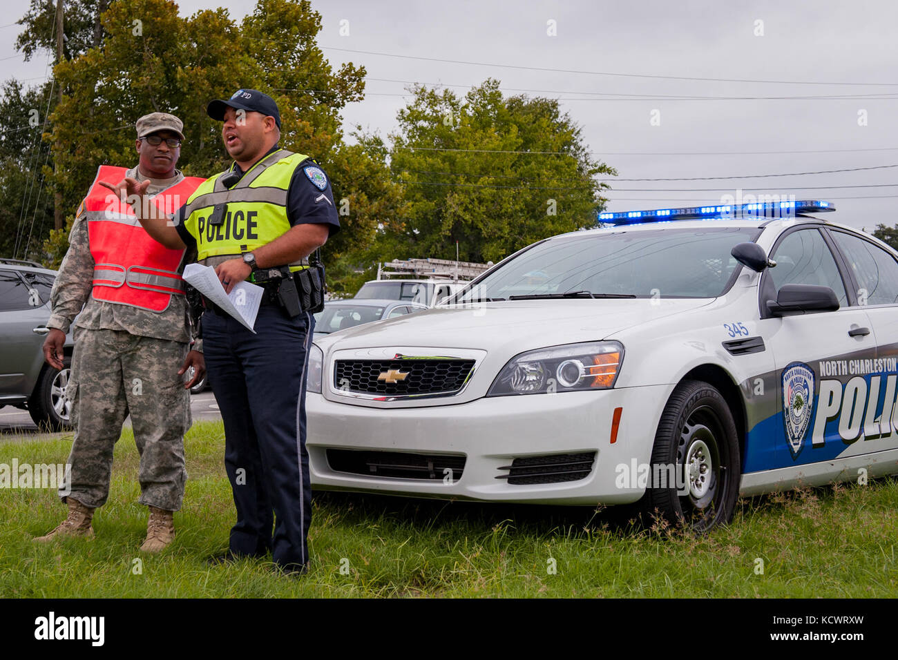 U.S. Army Pvt. 1st Class Bradley Burgess of C. Co. 1-118th Infantry Co., South Carolina Army National Guard and City of North Charleston Patrolman 1st Class Giovanni Brown manage a traffic control point in North Charleston, S.C., Oct. 5, 2016.  Hurricane Matthew peaked as a Category 4 hurricane in the Caribbean and was projected to pass over the southeastern U.S., including the S.C. coast. Approximately 1,400 S.C. National Guard Soldiers and Airmen were activated Oct. 4, 2016, to support coastal evacuations after Governor Nikki Haley declared a State of Emergency. (U.S. Army National Guard pho Stock Photo