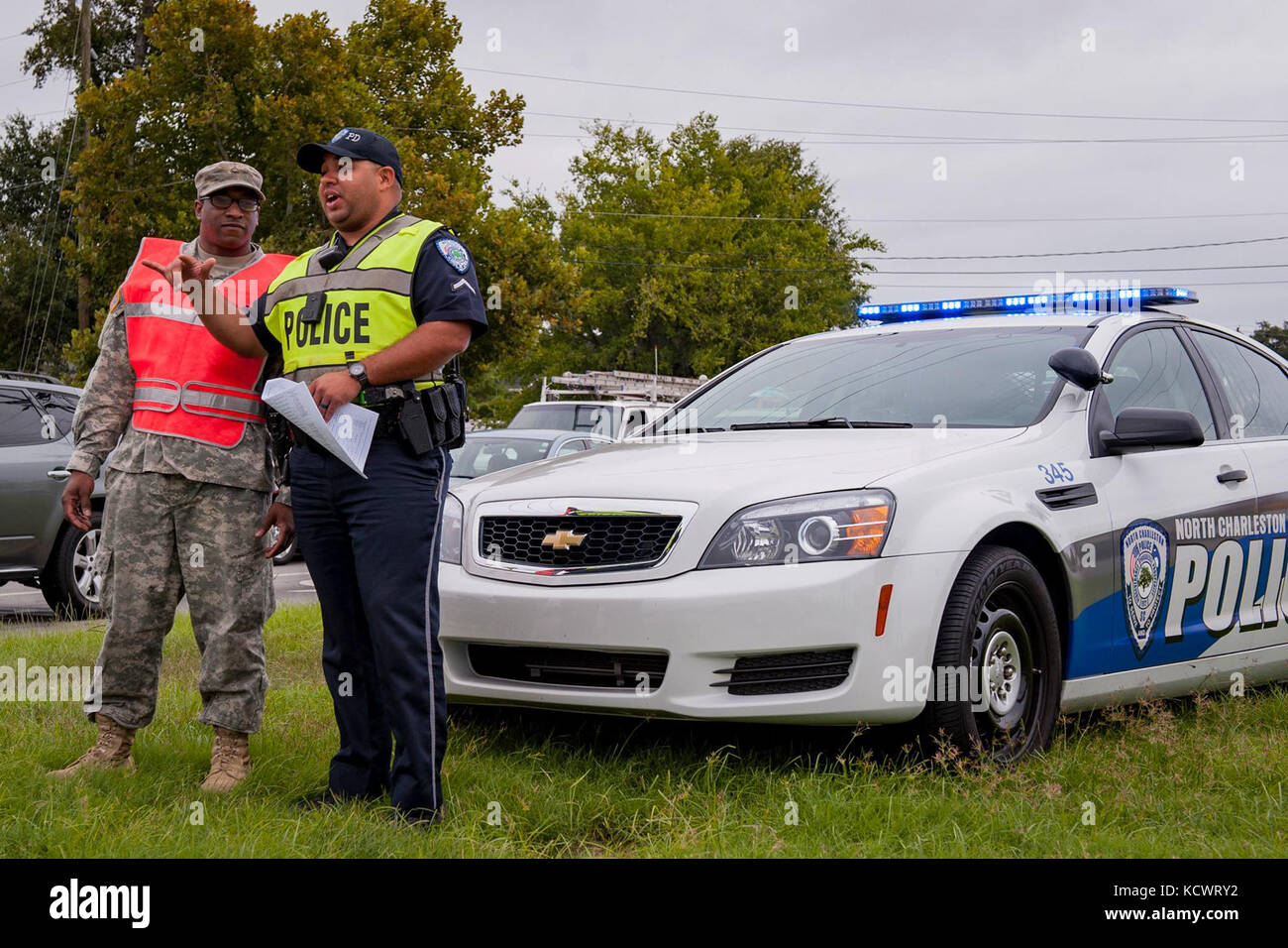 U.S. Army Pfc. Bradley Burgess, C Company, 1st Battalion, 118th Infantry Regiment, South Carolina Army National Guard, and City of North Charleston Patrolman 1st Class Giovanni Brown manage a traffic control point in North Charleston, South Carolina, Oct. 5, 2016. Hurricane Matthew peaked as a Category 4 hurricane in the Caribbean and was projected to pass over the southeastern U.S., including the S.C. coast. Approximately 1,400 S.C. National Guard Soldiers and Airmen were activated Oct. 4, 2016, to support coastal evacuations after Governor Nikki Haley declared a State of Emergency. (U.S. Arm Stock Photo