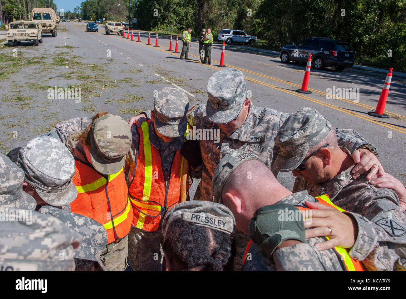 U.S. Army Chaplain, 1st Lt. Richard Brown of the 122nd Engineer Battalion for the South Carolina Army National Guard, leads a group of Soldiers in a moment prayer as they work to remove debris and clear the roadways in Bluffton, South Carolina, Oct. 9, 2016. Approximately 2,800 S.C. National Guard Soldiers and Airmen have been activated since Oct. 4, 2016, to support state and county emergency management agencies and local first responders after Governor Nikki Haley declared a State of Emergency. (U.S. Army National Guard photos by Sgt. Brian Calhoun, 108th Public Affairs Detachment) Stock Photo