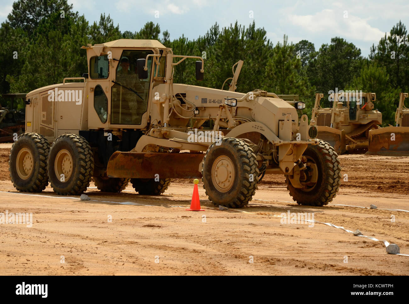 South Carolina National Guard Soldiers from the 124th Engineer Company, 172nd Engineer Platoon and the 1782nd Engineer Company competed in the Best Engineer Competition at the McCrady Training Center Aug. 5, 2016. As one of the horizontal engineer tasks, each Soldier had to operate a motor grader in a confined space by maneuvering the vehicle without knocking a softball off the top of a cone. This is the second year of the combined competition between the 178th and 122nd Engineer Battalions. (U.S. Army photo by 1st Lt. Jessica Donnelly, 108th Public Affairs Detachment) Stock Photo