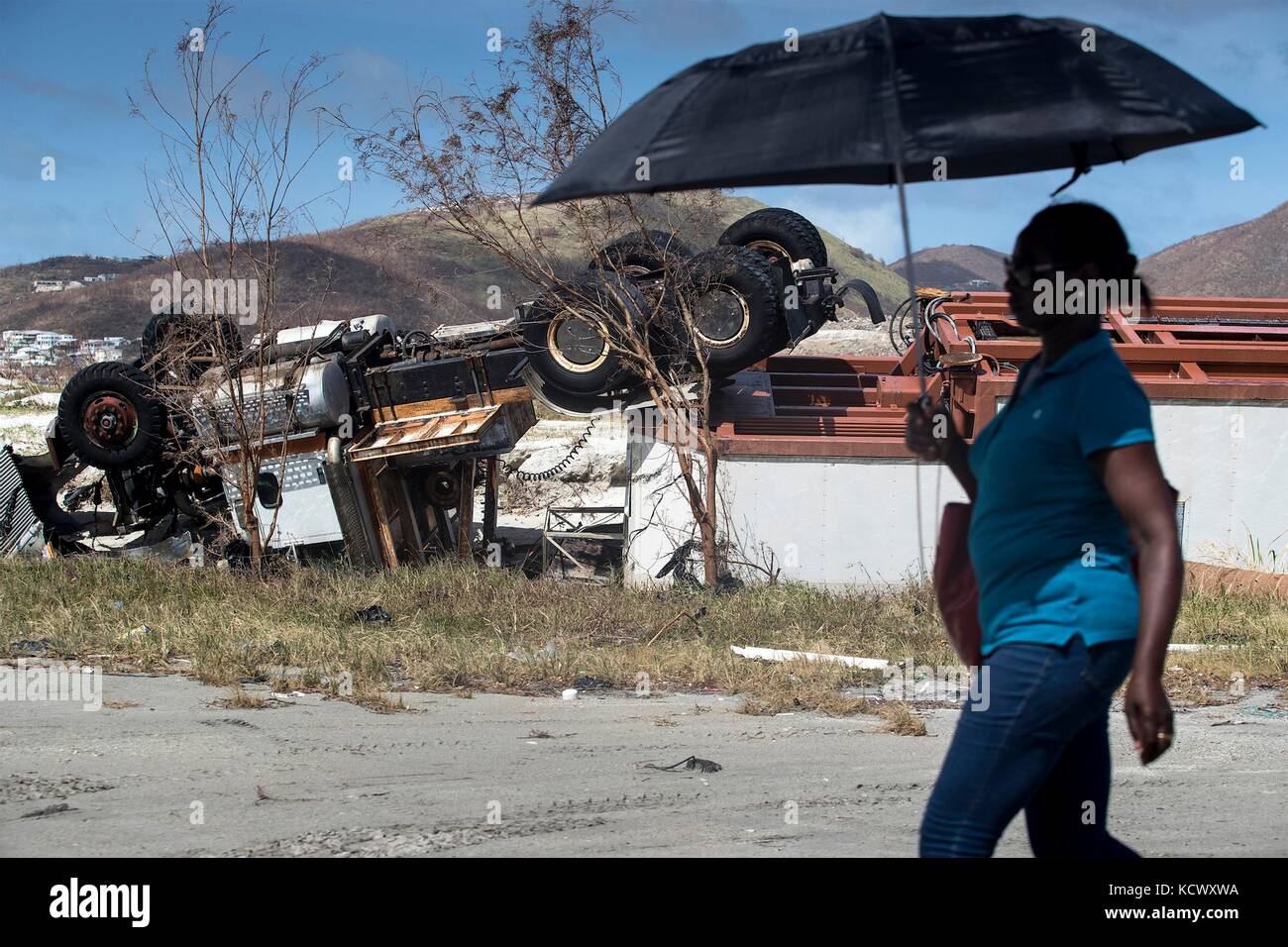 A resident walks past a destroyed truck in the aftermath of Hurricane Irma that devastated much of the Leeward Islands September 11, 2017 in Philipsburg, St. Maarten. Stock Photo