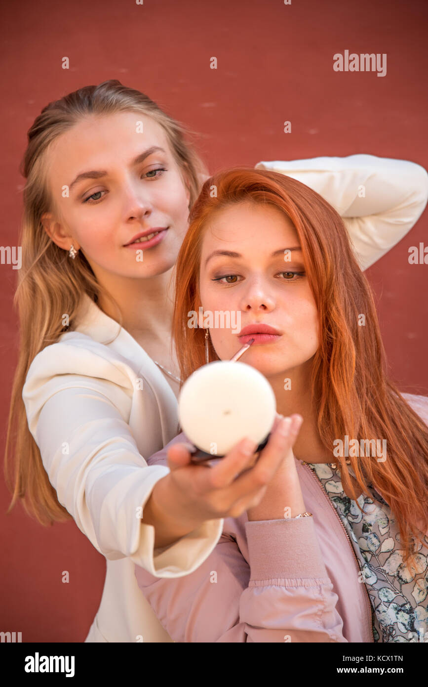 girl doing makeup on the street. Colour lips Stock Photo