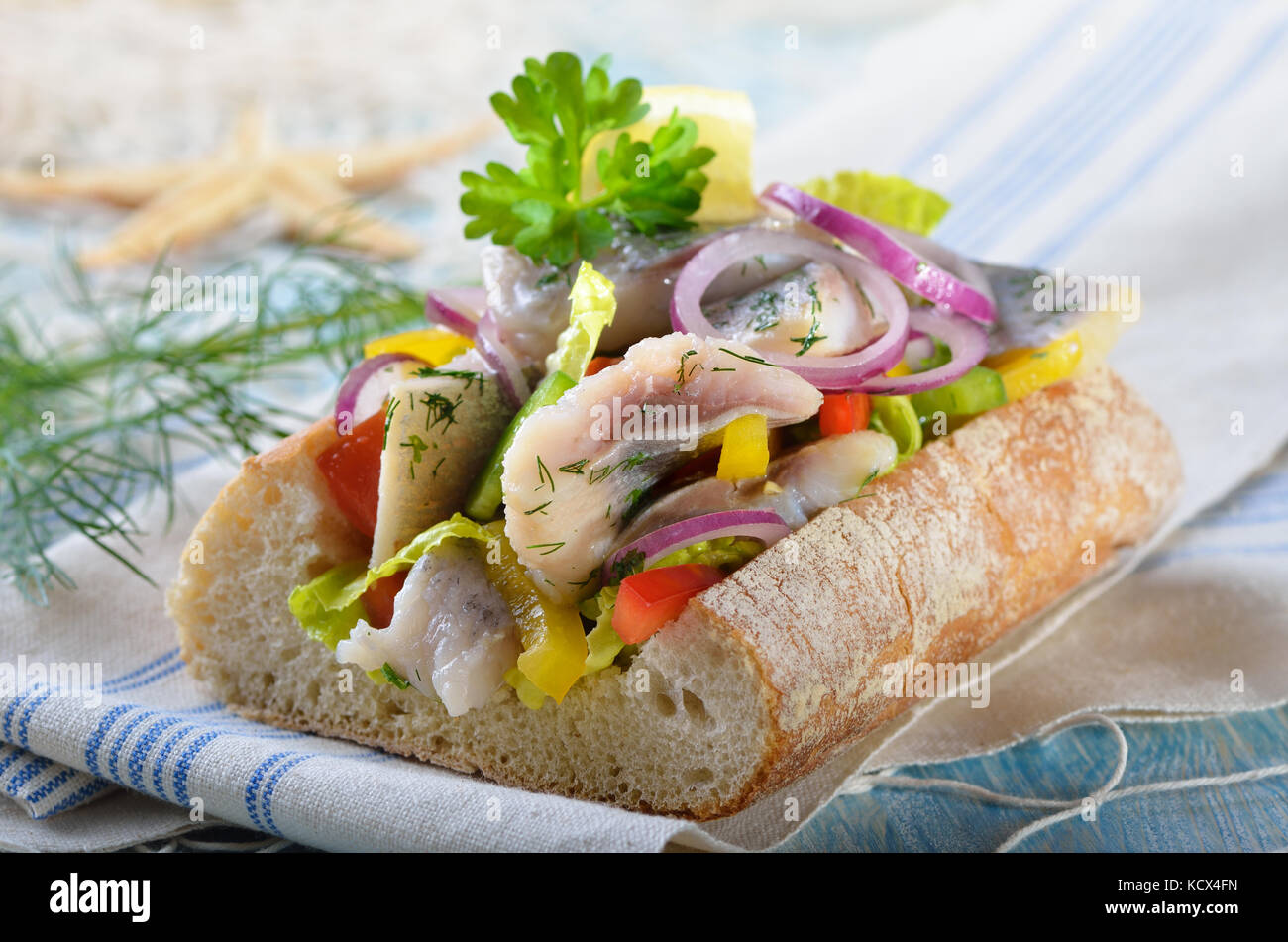 Delicious salad of salted fillets of white herring filled in Italian ciabatta bread Stock Photo