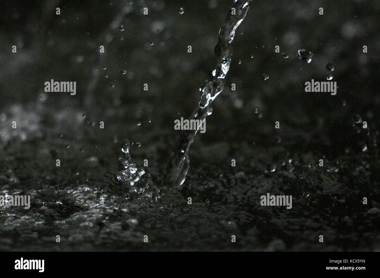 picture of a Water drops levitating in the air in dark. Splashing water ...