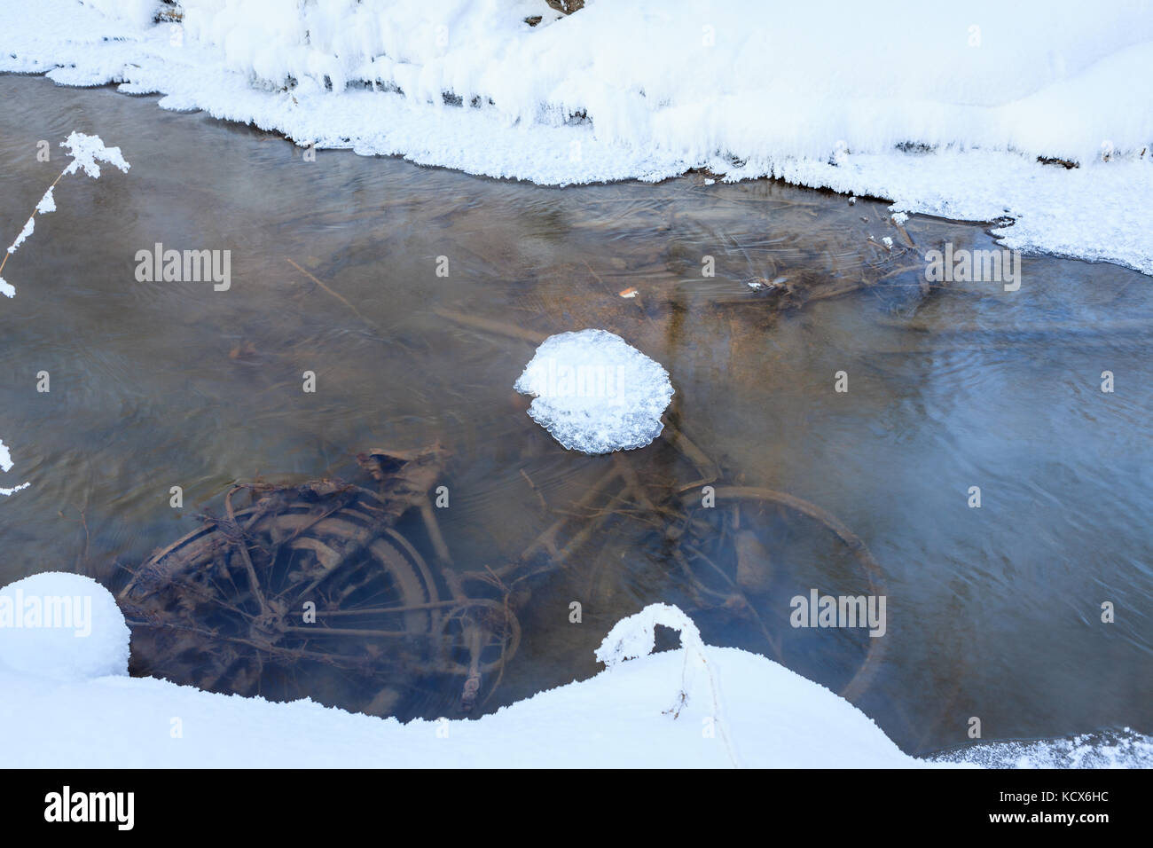 Abandoned bicycle in small stream Stock Photo
