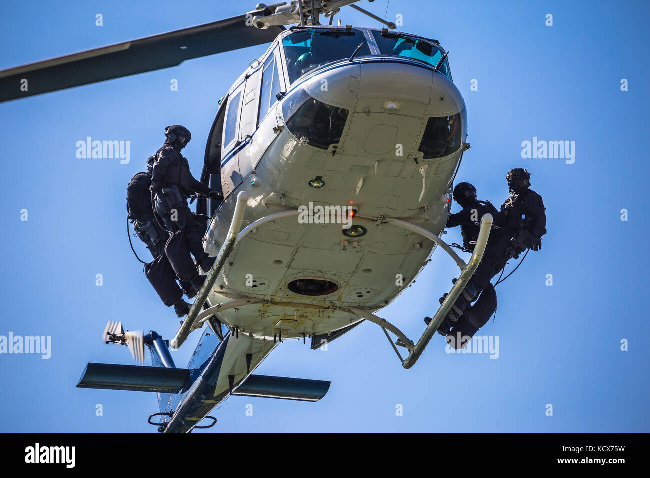 Special forces team ready for helicopter rope jumping, unmarked and unrecognizable swat team Stock Photo