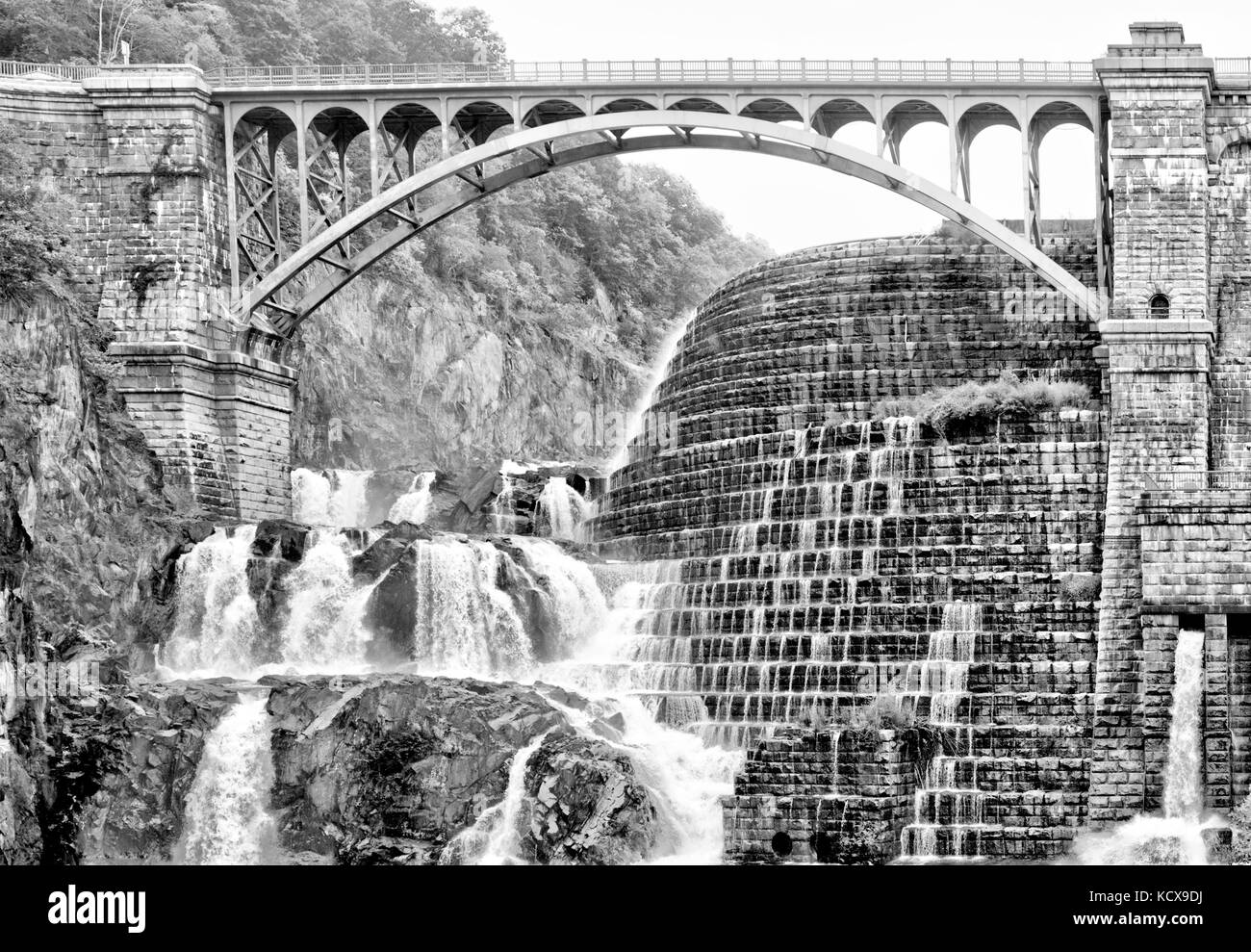 A man made dam along with natural rocks creates a beautiful waterfall