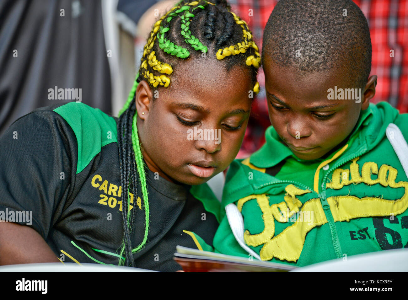 Jamaican kids reading at a stadium Stock Photo