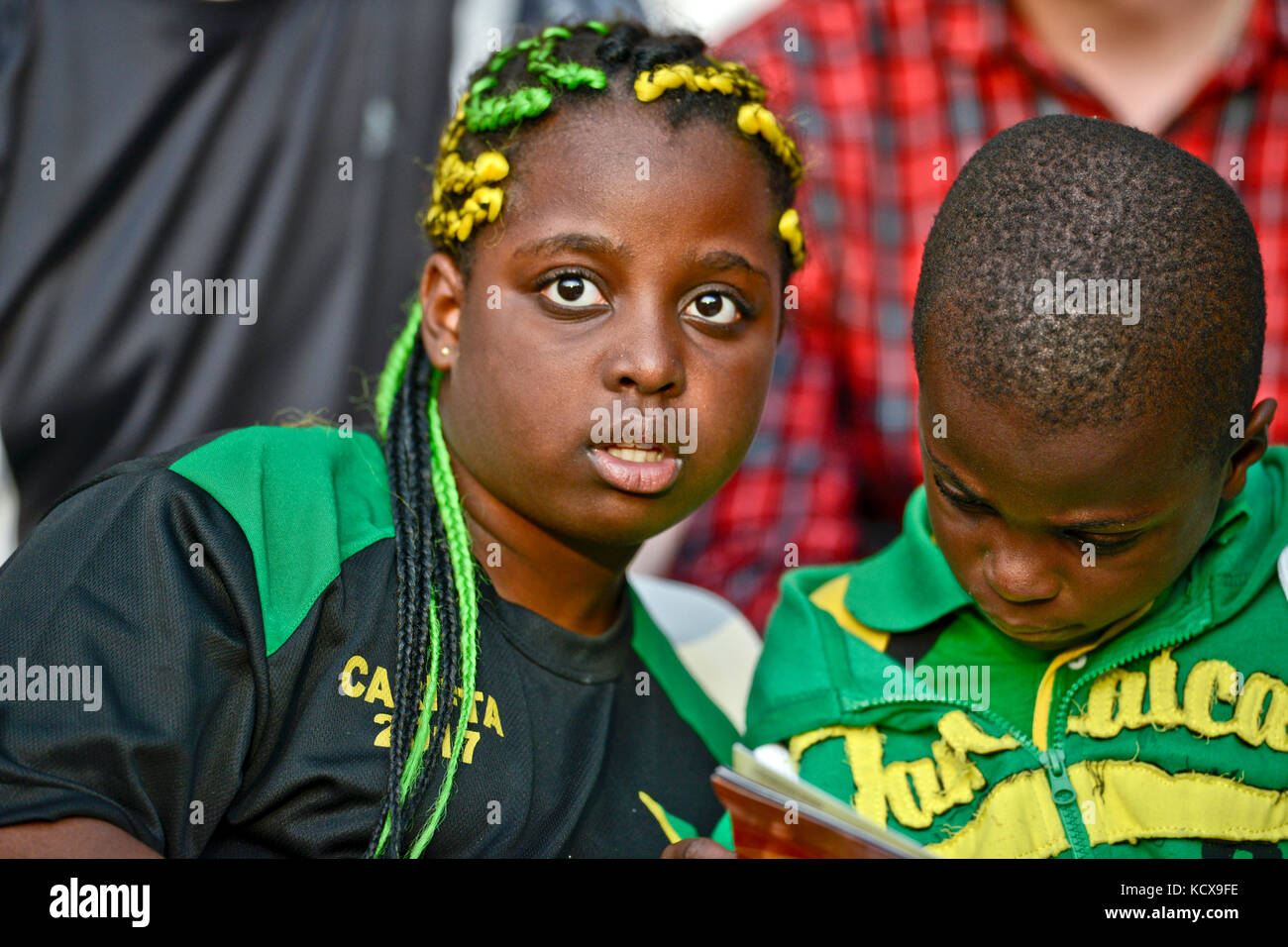 Jamaican kids reading at a stadium Stock Photo