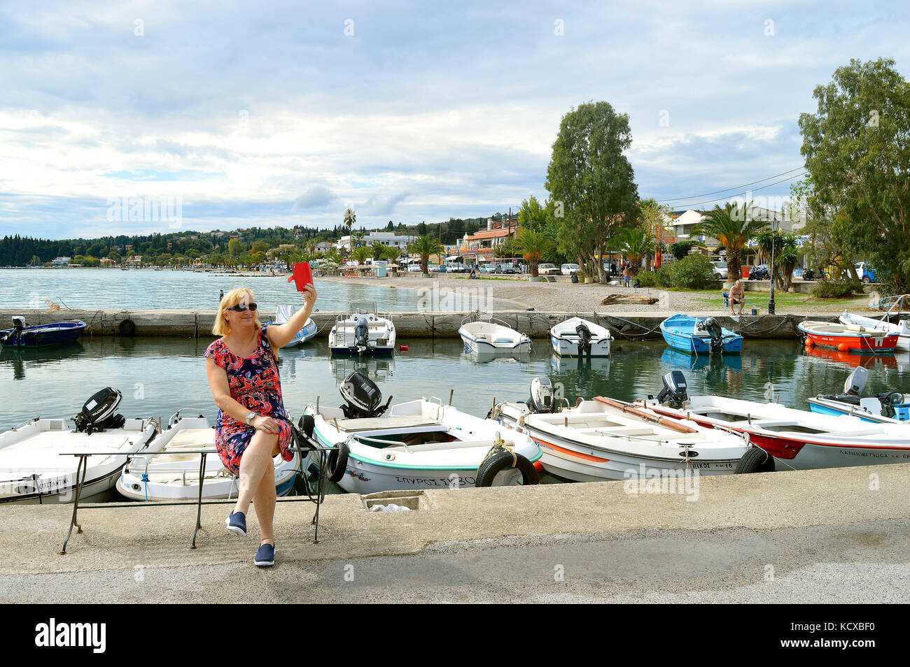 Lady taking a selfie at Ipsos Marina in Corfu Stock Photo