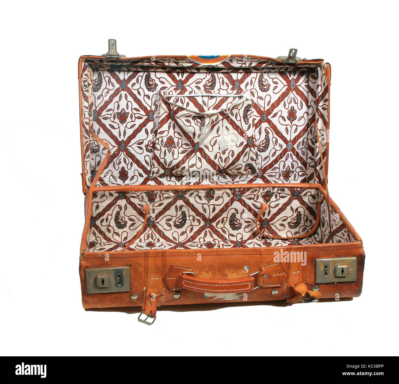 Open vintage leather suitcase with batik lining on white Stock Photo