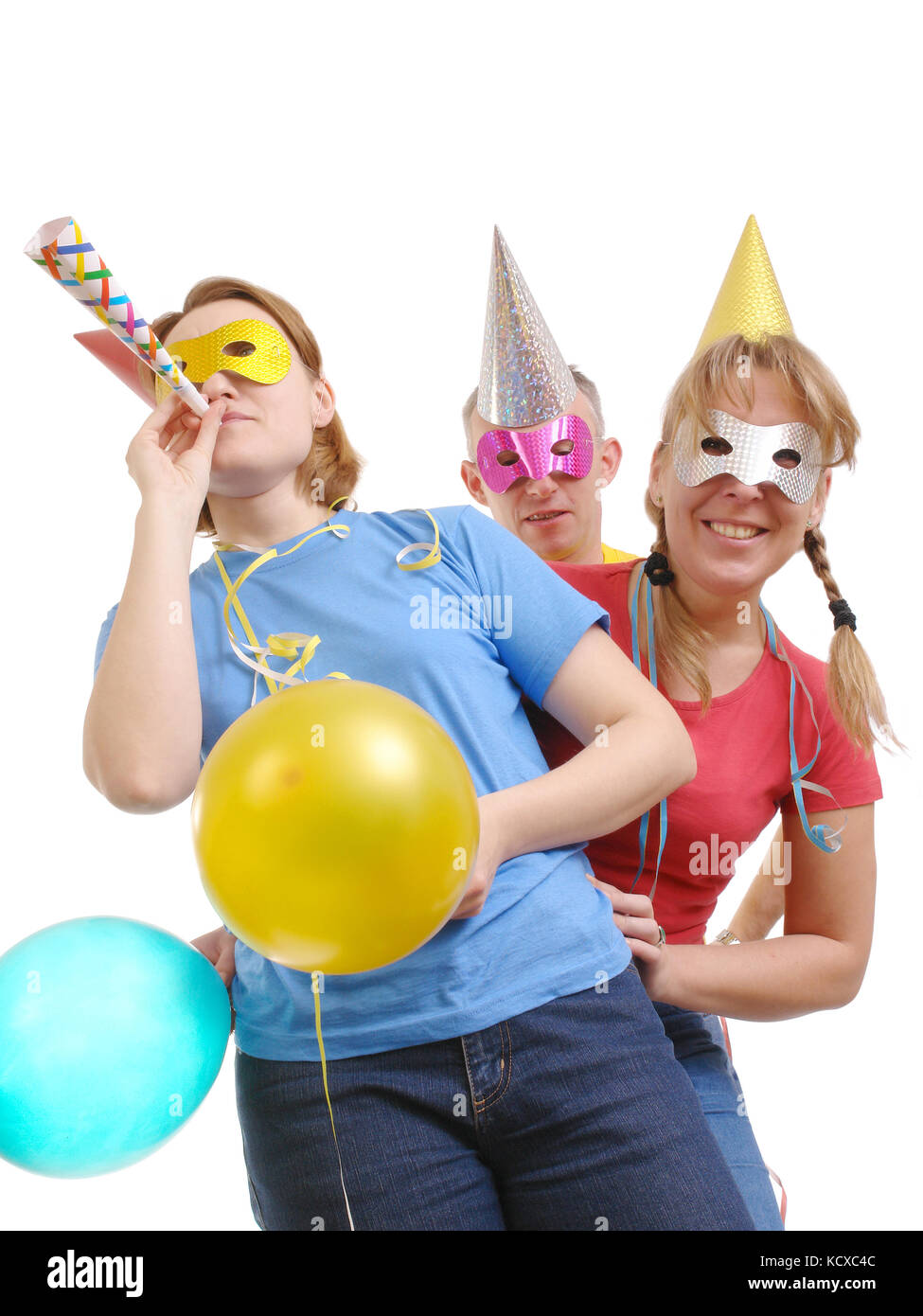Group of friends wearing party masks and hats posing over white Stock Photo