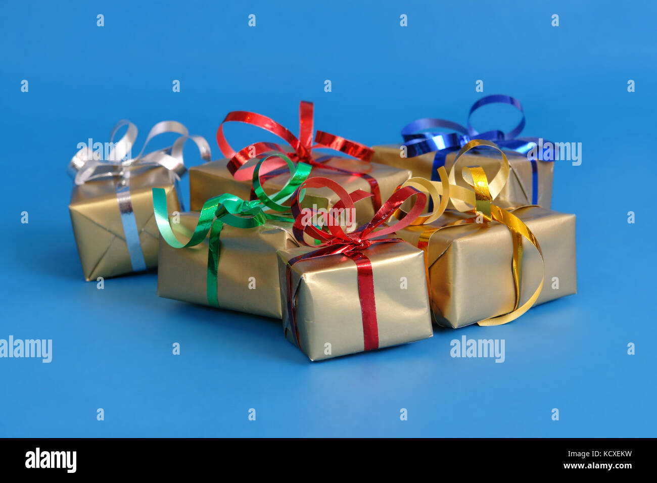 Group of christmas presents wrapped into golden paper over blue background Stock Photo